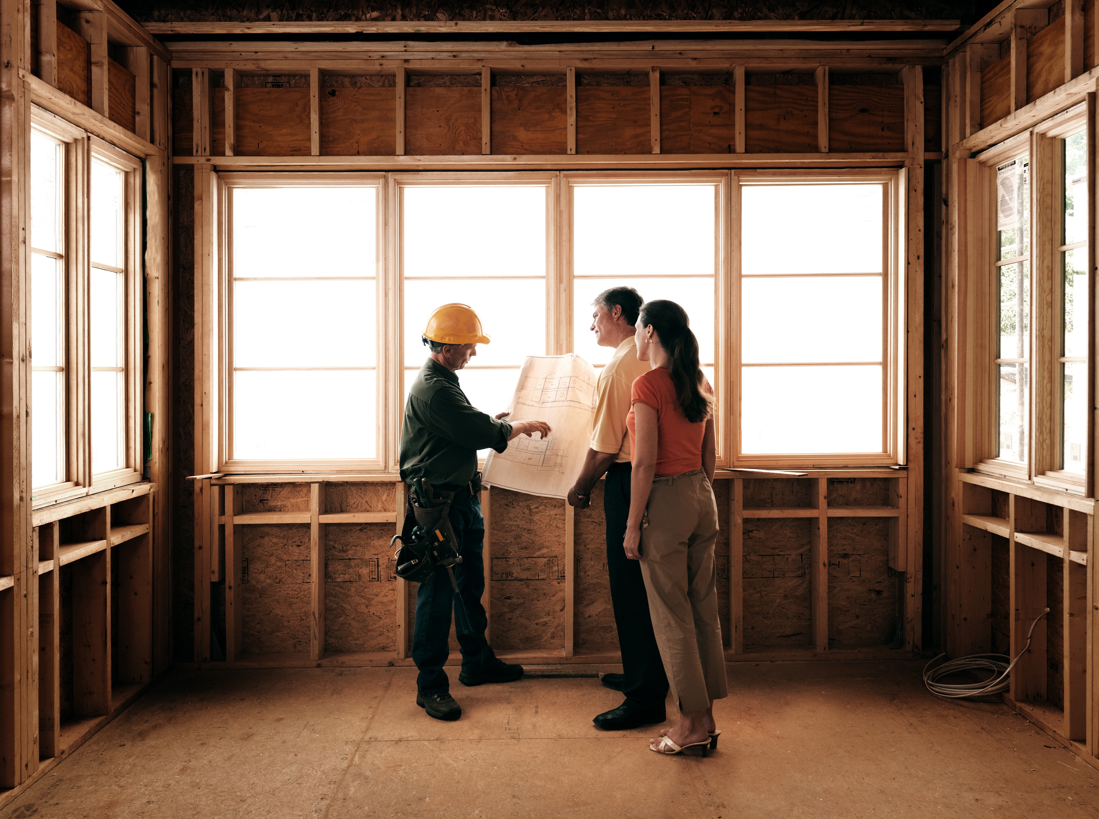 A contractor walks homeowners through plans for an addition.