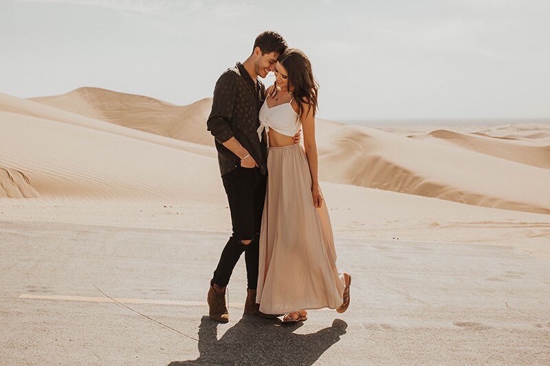 Influencers Jess and Gabriel Conte dance together in front of a desert landscape