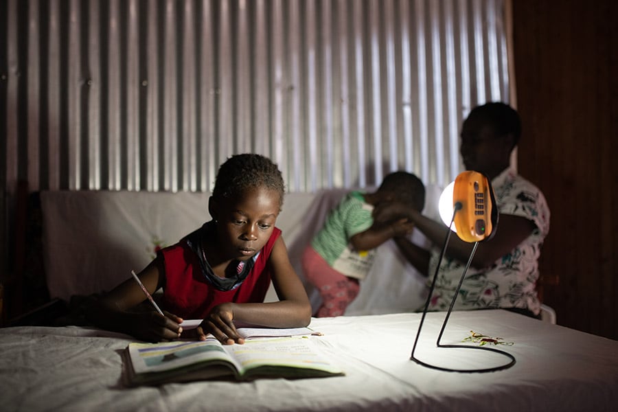 Children study by solar-powered lantern