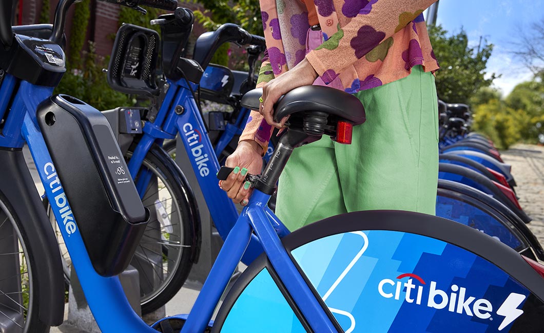 A woman adjusts her Citi Bike seat at the dock