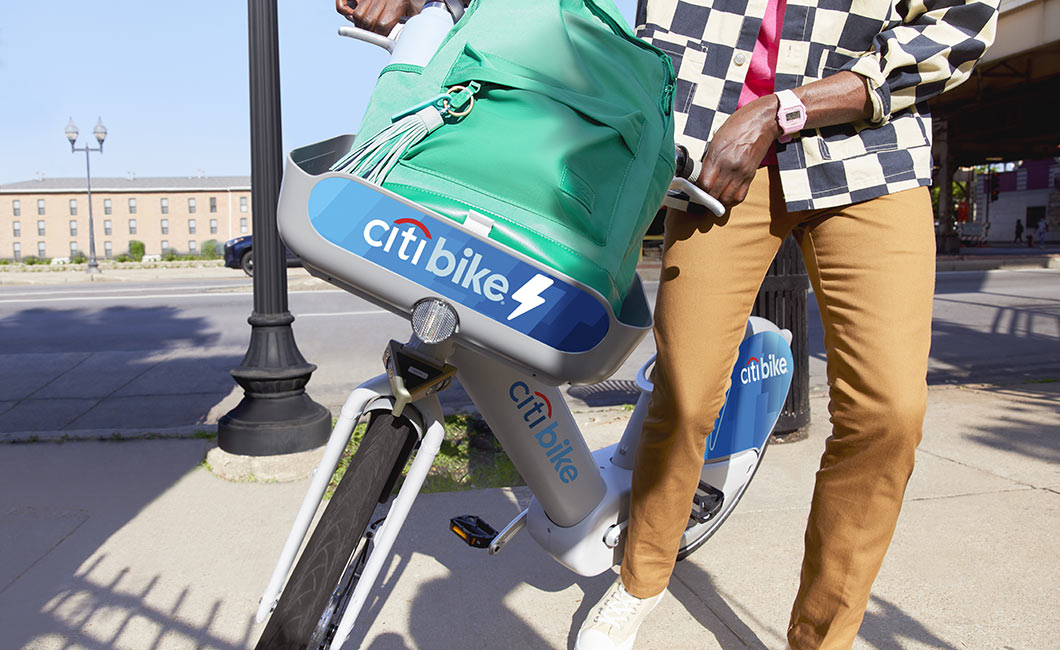 A man puts his backpack in his basket sets off on a Citi Bike ride