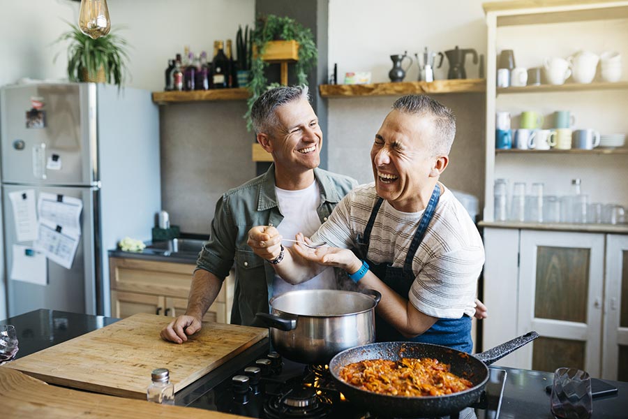 A couple with two men enjoys cooking at home