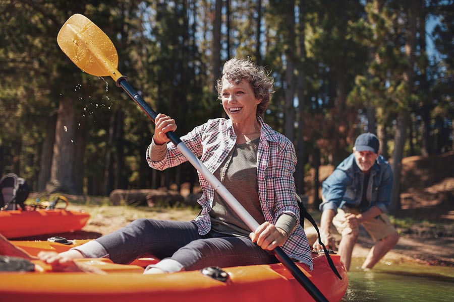 A man pushes a woman out on a kayak