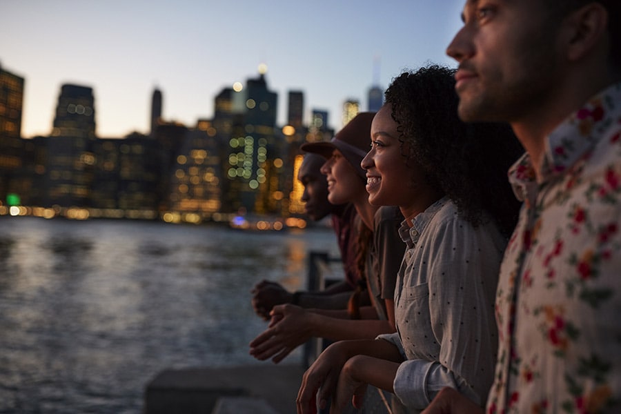 Four friends look out upon the New York City skyline