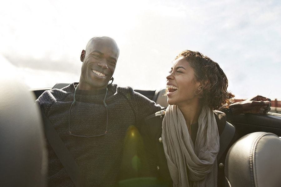 Couple sitting in the backseat of a convertible car