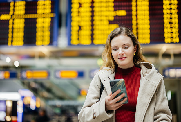 A woman checking her phone at the airport
